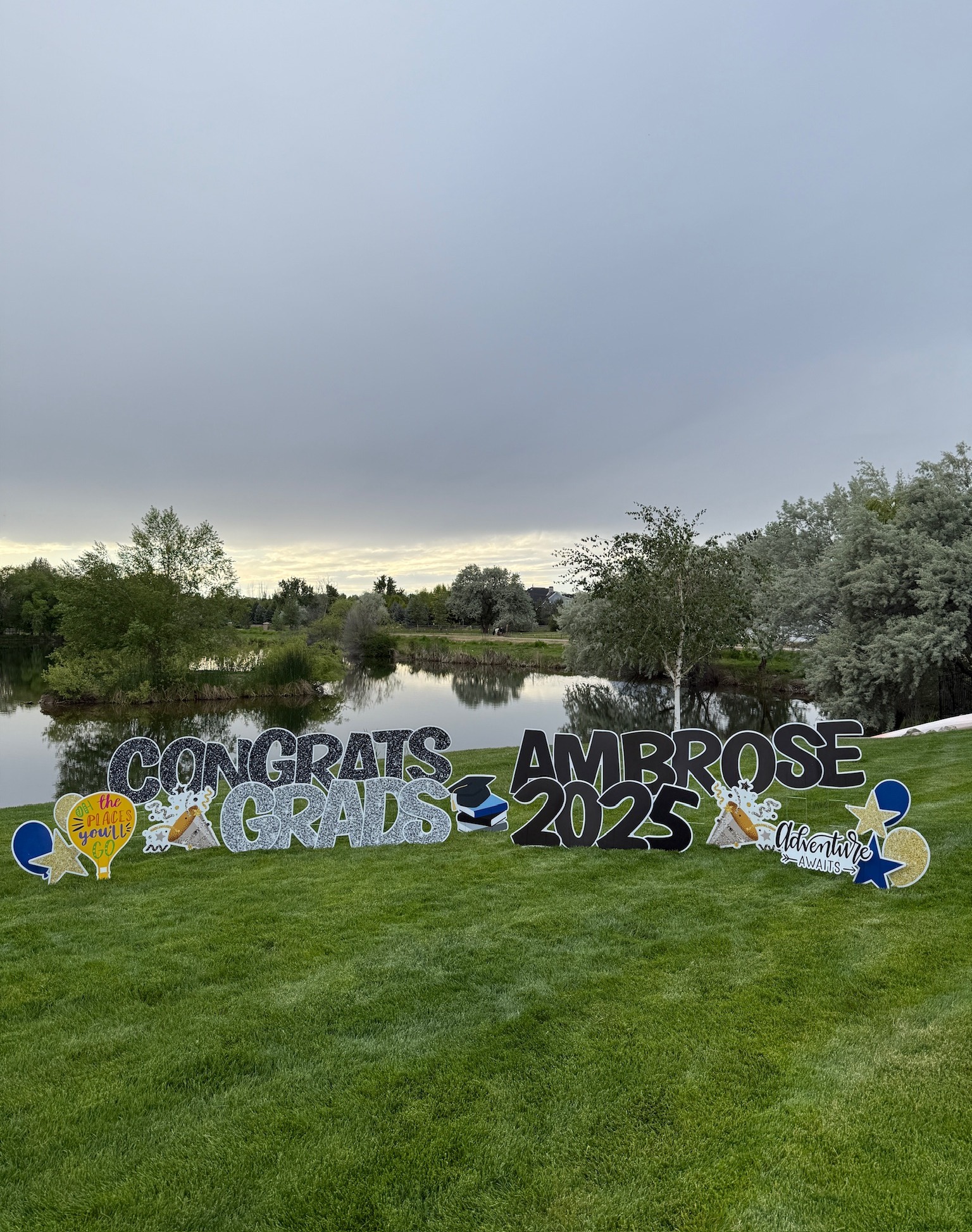 Congrats Ambrose Grads 2025 graduation yard card display on a scenic waterfront property in Boise Idaho